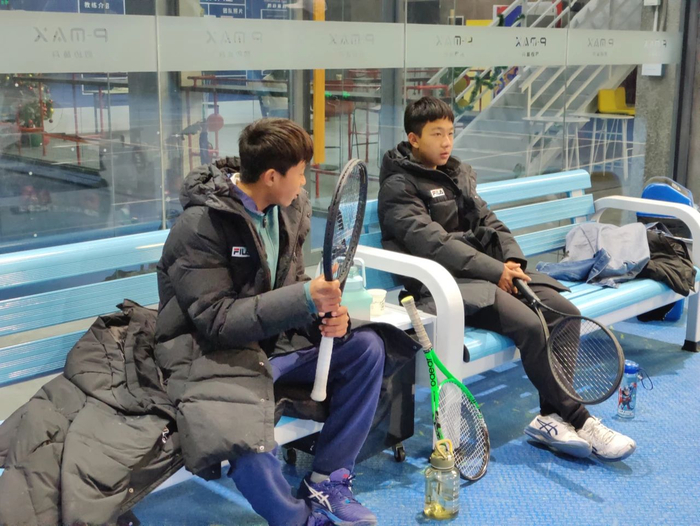 2022年12月31日，队内比赛结束后，王发（左）坐在场边和队友复盘比赛经过。新京报记者 汪畅 摄