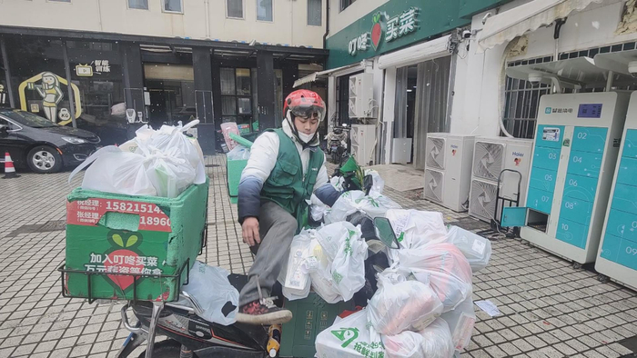 　图为叮咚买菜普陀白玉站配送员冒雪配送订单。