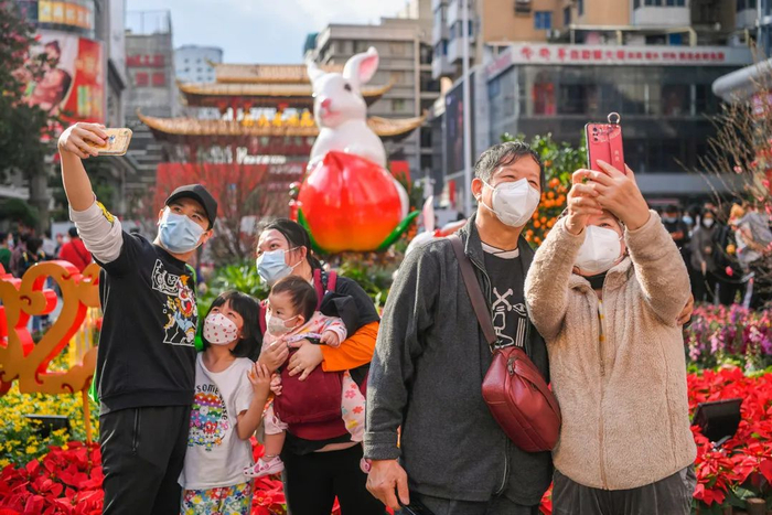 市民正在越秀西湖花市牌楼兔年装饰前拍照留念。信息时报记者 胡瀛斌摄