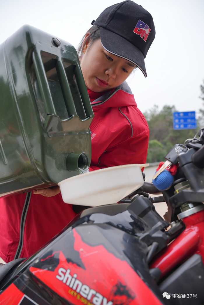 吴朴慧出去骑车时，往车里加水。新京报记者 贺俊怡 摄