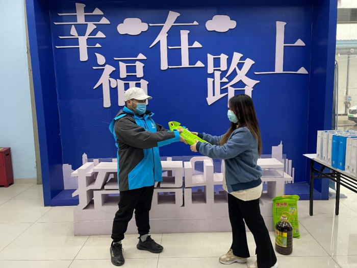 ▲春节留守司机在重庆招招出行司机线下服务中心领取慰问物品/图源 高德