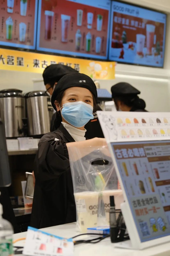 ▲古茗小姐姐正在给顾客出杯。（图片来源：古茗）