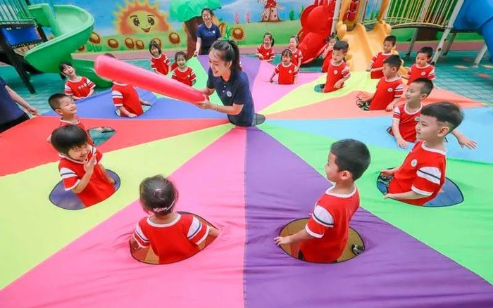▲2022年7月28日，河北省遵化市一所幼儿园的老师组织暑期托管班的孩子们做游戏。图/新华社