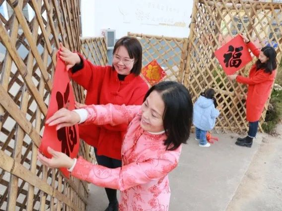 2023年1月12日，在山东省高密市某研学实践基地，密水街道中心幼儿园的师生家长们在一起贴福字。李海涛 摄