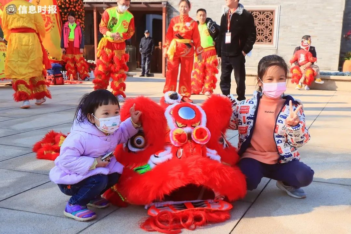 海珠湿地迎春赏花集市1月19日开幕，小朋友在醒狮前合影。信息时报记者 郭柯堂 摄