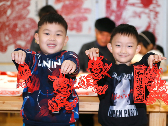 2023年1月13日，山东省青岛市即墨区龙山街道孩子在展示兔子图案的剪纸作品。梁孝鹏 摄