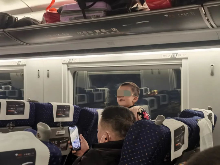 ▲2023年1月10日，上海开往成都的动车上，带孩子的男子正在刷短视频。新京报记者 李照 摄