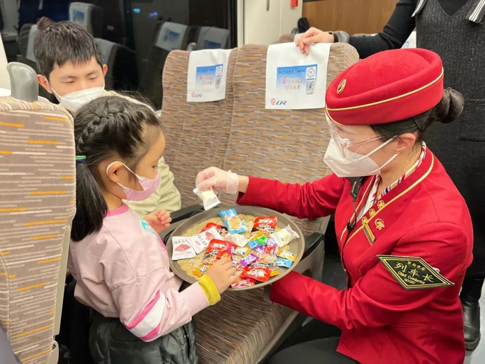 ▲2023年1月19日，G39次北京南站开往杭州东站的列车上，常哲心在给小乘客发放糖果。受访者供图