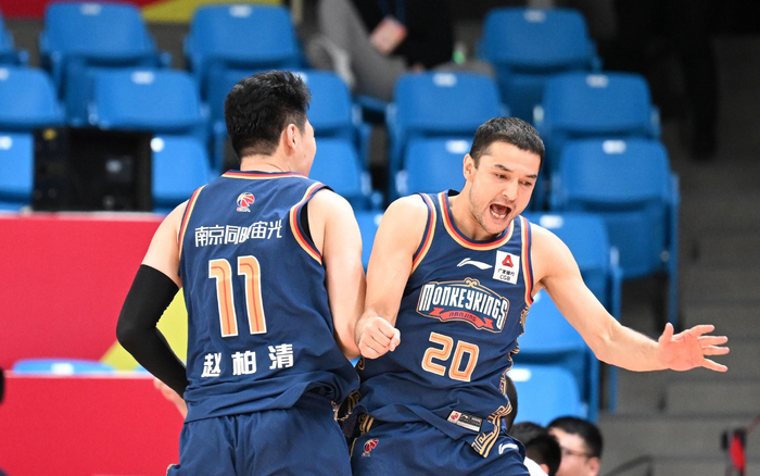 西热力江（右）在场上用激情带动队员。  图/新华社