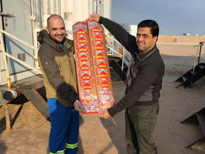 大庆钻探伊拉克鲁迈拉项目DQ022钻井队外籍员工卡拉和艾哈迈德正在展示英文春联。