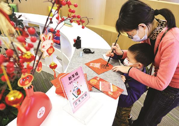             今天上午，上海少年儿童图书馆，家长带着孩子一起写下新年“福”字  本报记者  王凯  摄          