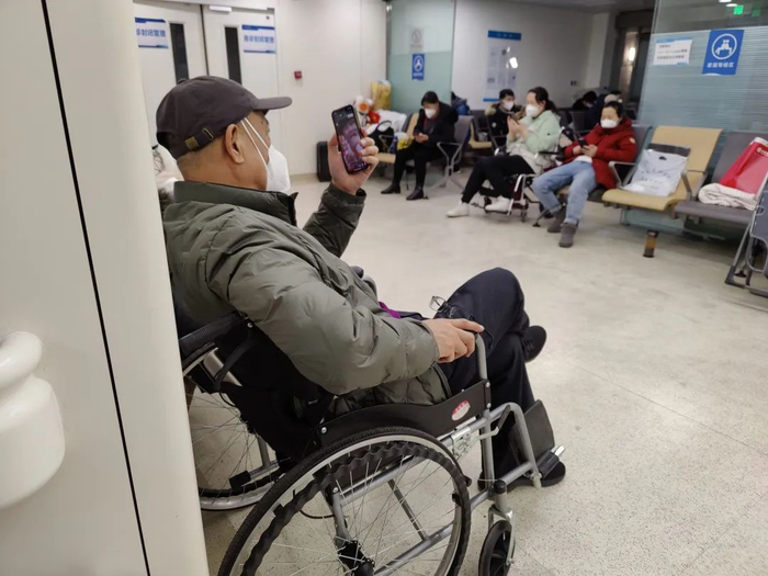  ▲1月21日下午8时许，一名抢救室患者家属在观看央视春晚。新京报记者 吴小飞 摄