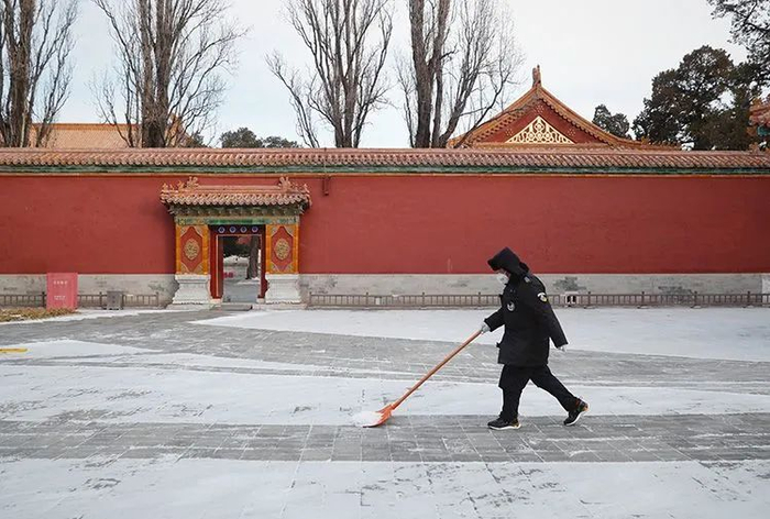 ▲景山公园工作人员为游客清扫出雪中步行道