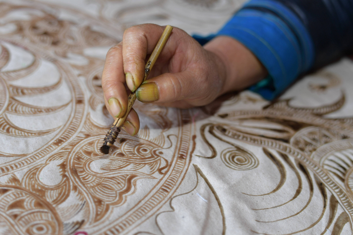 贵州蜡染手工艺人在点蜡作画。图片来自新华社
