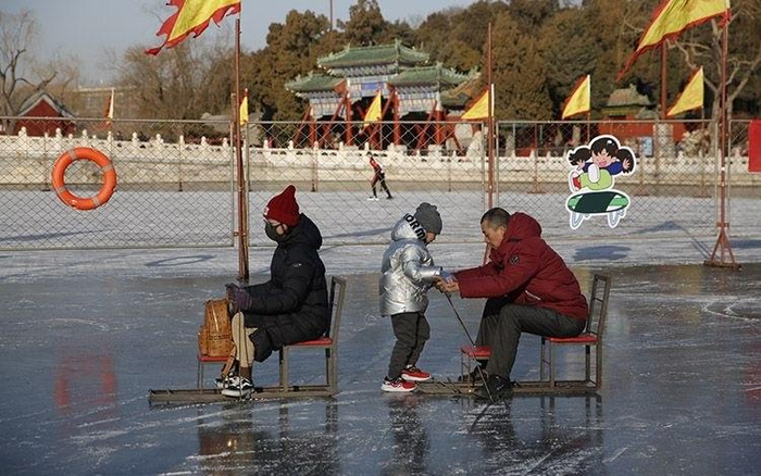 一家三口在冰场体验滑冰车游乐项目。图/新京报资料图片
