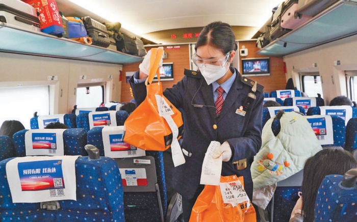 1月19日，G321次列车上，铁路工作人员正在为旅客派送高铁外卖。陆逸 摄