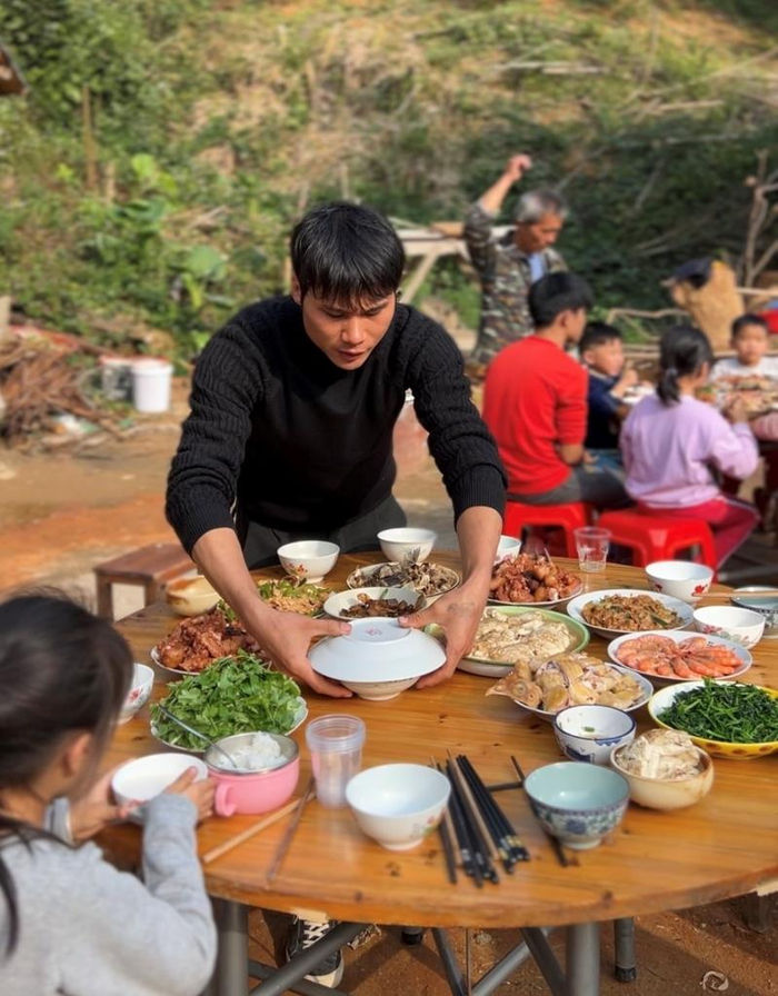 大年三十，陆石坤在老屋前准备饭菜。（受访者供图）