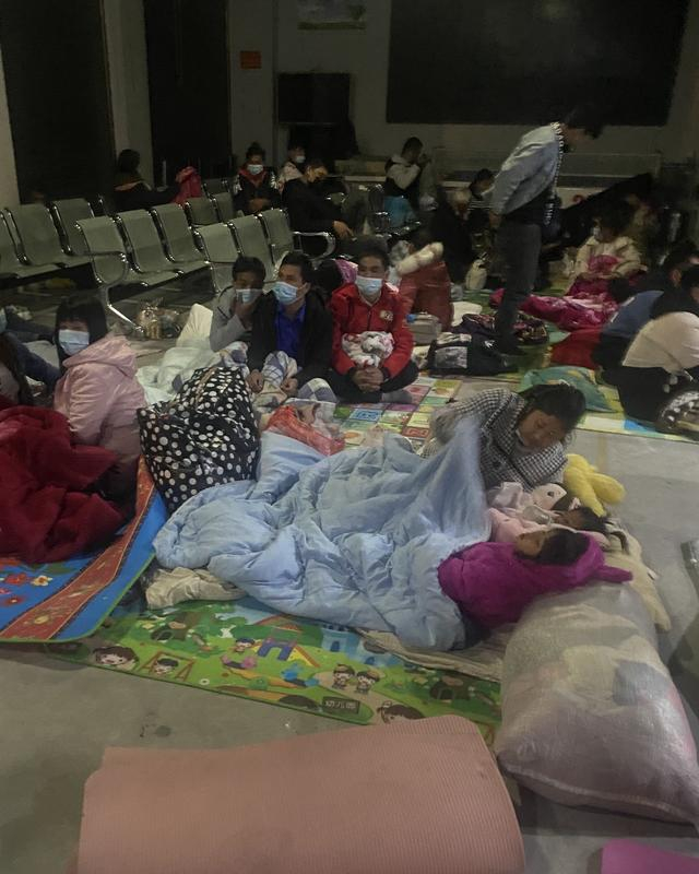 1月12日晚，不少缅籍人员办完相关手续后，直接在服务大厅领了铺盖，席地而睡，等天亮回家。澎湃新闻记者陈灿杰 图