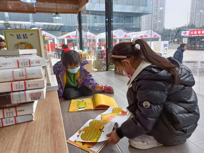 ▲小朋友仔细观看少儿绘本（刘霞 摄）