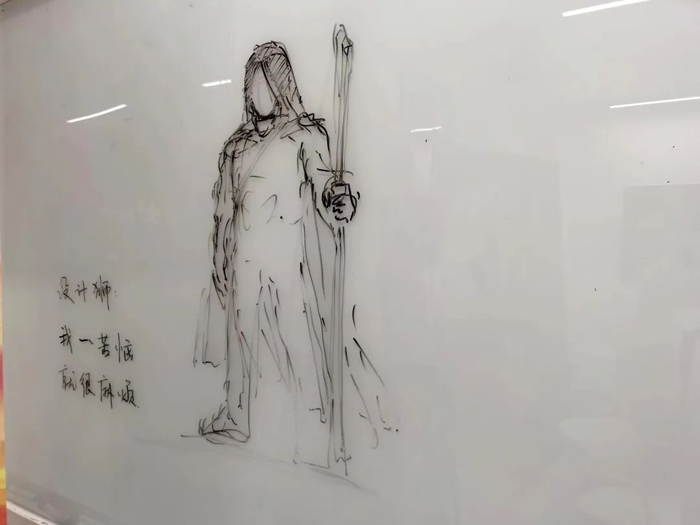 工作室展板上的一处涂鸦，“设计狮：我一苦恼，就很麻烦。”