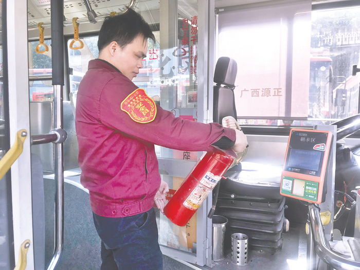     马福接检查车上的消防器材。（罗雯 摄）