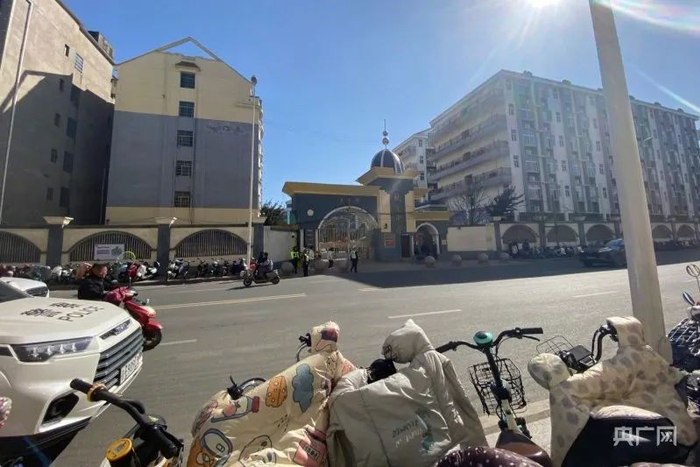 在致远中学门口，马路两边停满了自行车和电瓶车，门前有警车值守（央广网记者胡斐 摄）