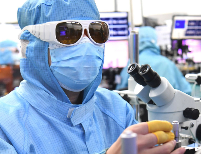 锐科激光生产车间，身着防尘服和保护眼镜的员工在各自岗位上精心操作仪器设备抓紧生产。 长江日报记者高勇摄  长江日报供图