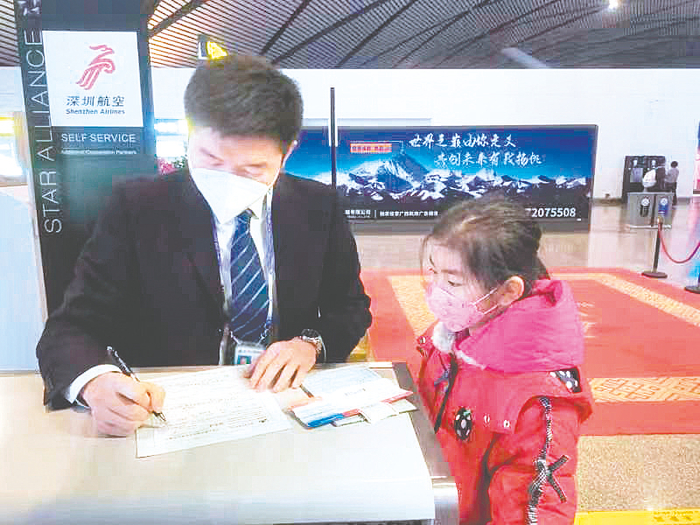     谢浩认真核对一名无陪儿童的信息。    （张哲杰 摄）