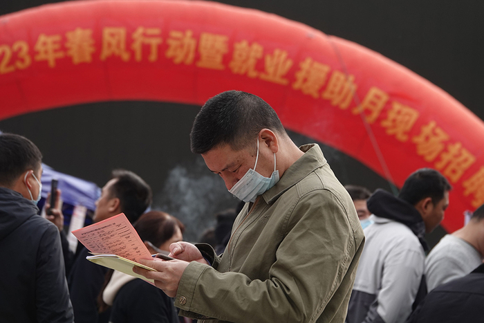 2023年1月29日，南宁，求职者在招聘会上查看招聘企业的岗位信息。喻湘泉 摄