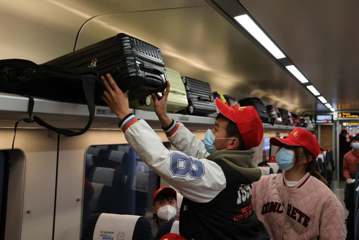 1月30日，旅客在D2879次务工专列上放行李。