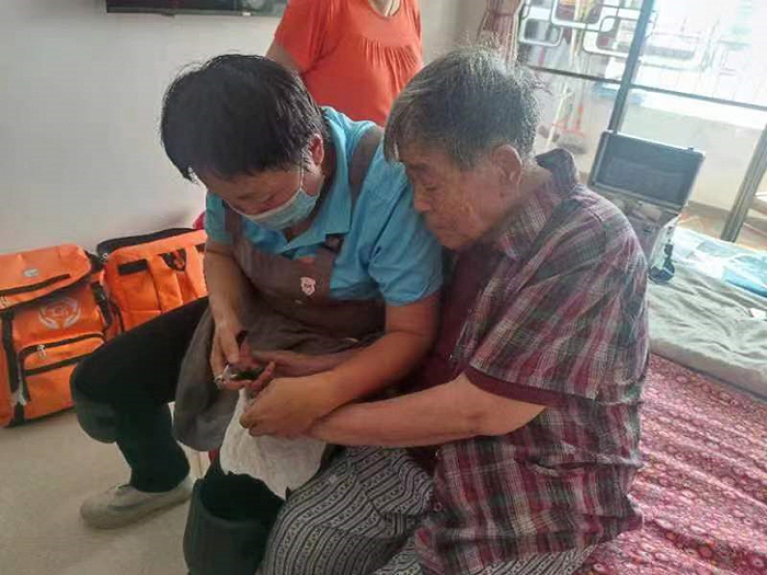 邹蓉帮老人修剪指甲，受访者供图