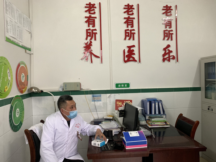 谭延平独自坐在村卫生室里。