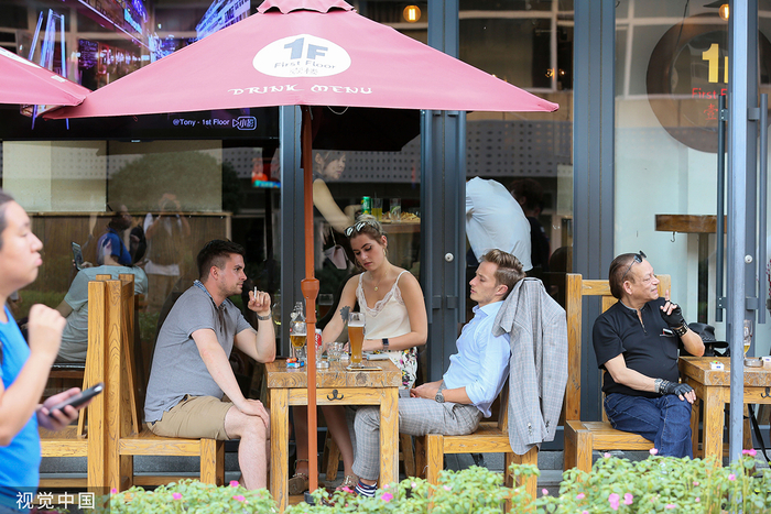 2018年8月18日，北京，三里屯酒吧街，在店里喝啤酒的外国人。