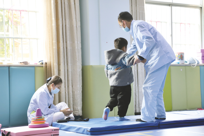     康复师指导孩子进行专业康复训练。 （谢长伟 摄）