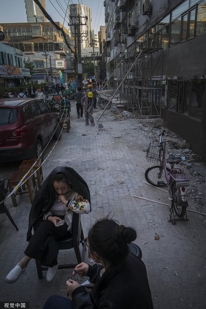 2017年4月26日，北京，脏街在整修。商家在店外等顾客。潘松刚/人民视觉 图