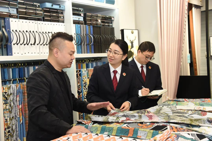 承办检察官走访轻纺城市场的商户。