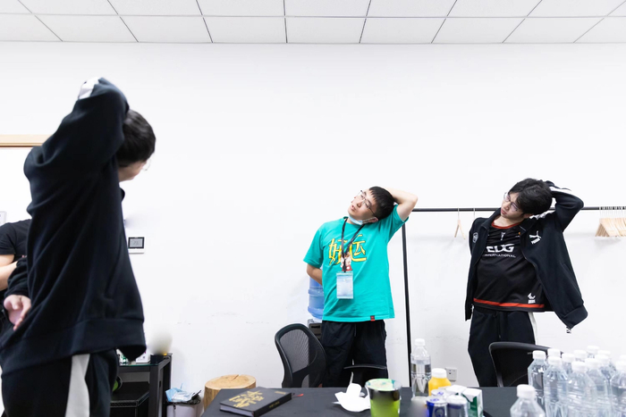 EDG电子竞技俱乐部的选手在刘文（中）带领下放松颈椎。  图/EDG电子竞技俱乐部