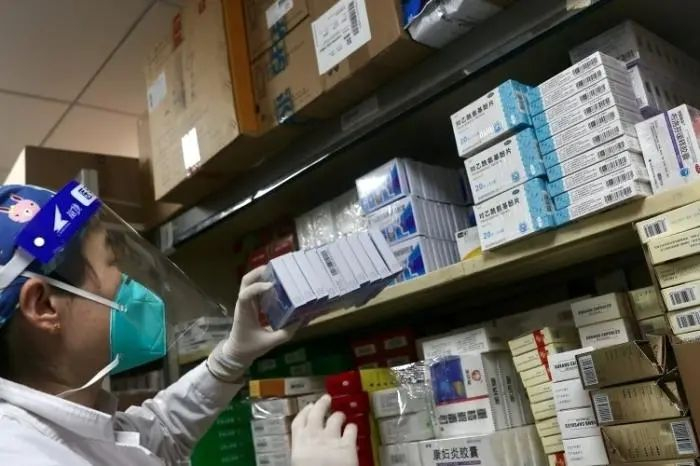 资料图：医务人员正将配送到的感冒药放入药架。中新社记者 易海菲 摄