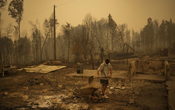 当地时间2023年2月5日，智利，Santa Juana发生火灾后，人们正在清理被野火摧毁的房子残骸。