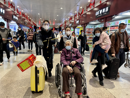     1月30日，郑州火车站客运车间客运二班客运员马蕊，正在为行动不便的老年旅客提供乘车一条龙服务。李静/摄