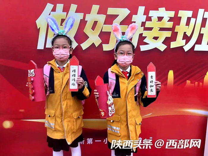 西安高新区第二十小学的学生们在校门口抽取新学期幸运签。