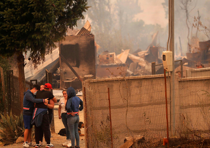 当地时间2023年2月3日，智利，Santa Juana发生火灾，人们在被摧毁的房屋旁哭泣。