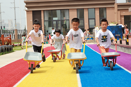     孩子们推着小车在赛路。本版图片由“奇色花”幼儿园提供