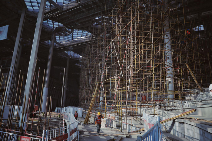 2023年2月7日，城市副中心三大建筑建设现场，工作人员正在城市副中心图书馆内搭建脚手架。  新京报记者 薛珺 摄