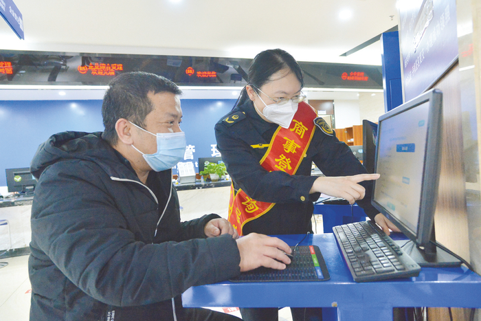     南宁市市场监管局工作人员指导群众办理相关业务。    本报记者 黄维业 摄