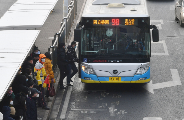 2月10日，东三环双井桥附近，市民排队乘坐公交车。  新京报记者 王贵彬 摄