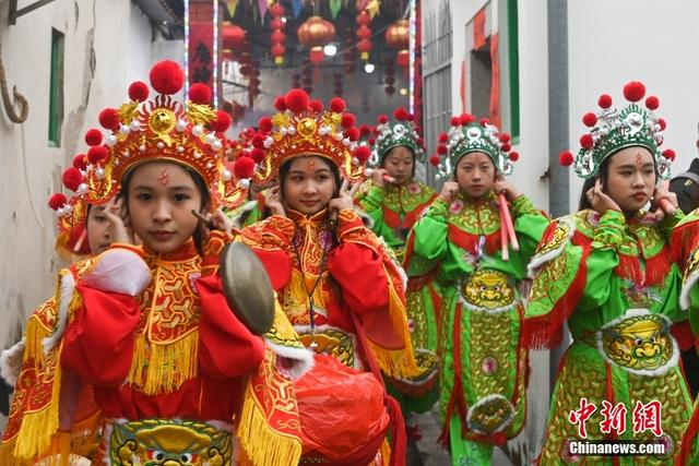 图为潮阳西门女子英歌队队员们在表演前听到鞭炮响声时，捂紧耳朵。中新社记者 陈楚红 摄