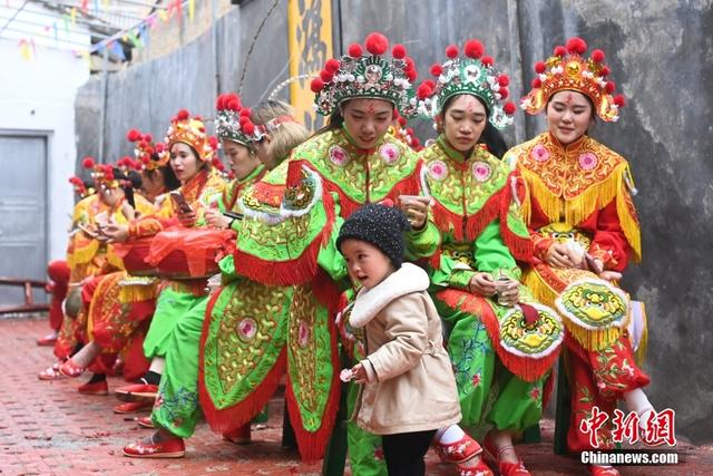 图为潮阳西门女子英歌队队员在休息间隙，一名小朋友好奇地上前跟队员互动。中新社记者 陈楚红 摄