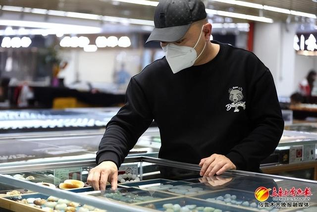 2月9日，华凌国际珠宝玉器城三楼，“品质商户”聚缘臻品店负责人正在整理展示柜内的各式玉器。记者赵莉 实习记者米热扎提摄