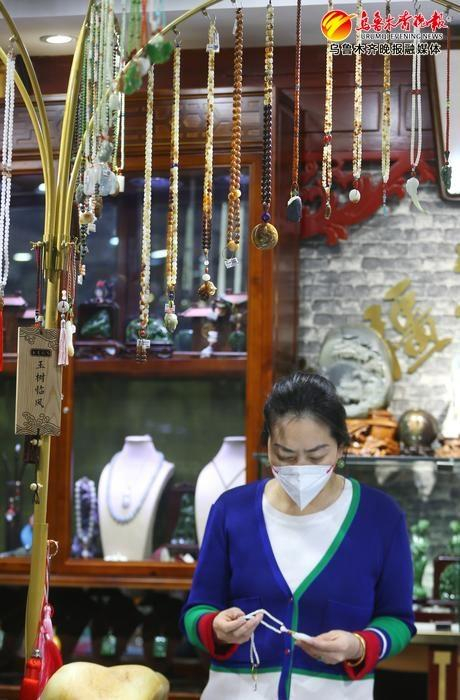 2月9日，华凌国际珠宝玉器城内，“品质商户”玉文胜器店内工作人员将各式玉器首饰摆放整齐。记者赵莉 实习记者米热扎提摄